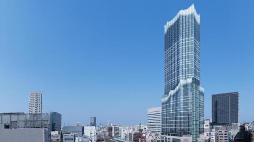 a tall glass building in a large city at 新宿中心高級稀有新建別墅，JR線新大久保徒步4分鐘露台免費Wi-Fi in Tokyo