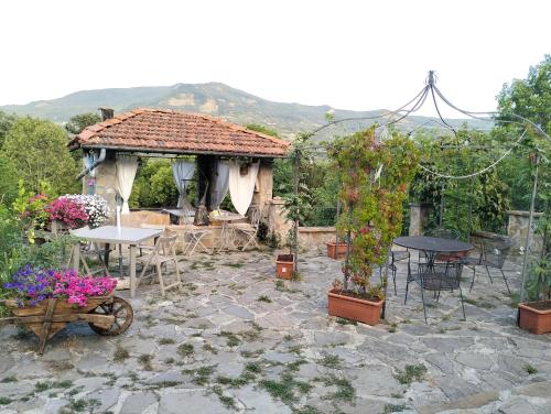 a garden with a table and chairs and a gazebo at la corte dei cerri in Spervara