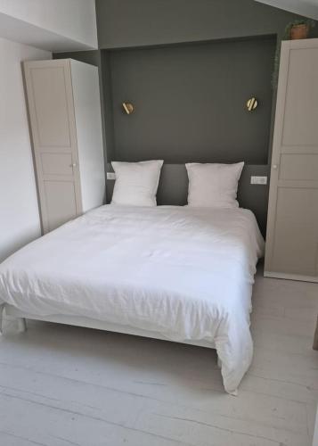 a large white bed with white sheets and pillows at Victoire Opale 202 climatisé hôtel de ville in Saint-Dizier