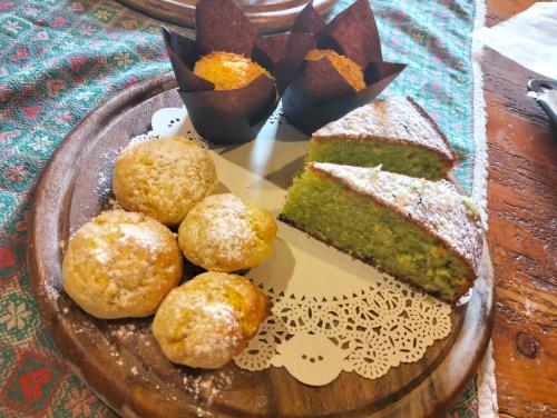 a plate of food with a slice of cake and muffins at la corte dei cerri in Spervara