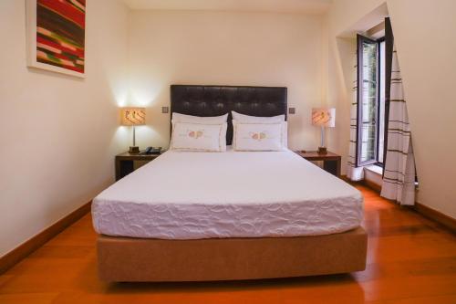 a bedroom with a large bed with two lamps at Eirado Hotel in Caldelas