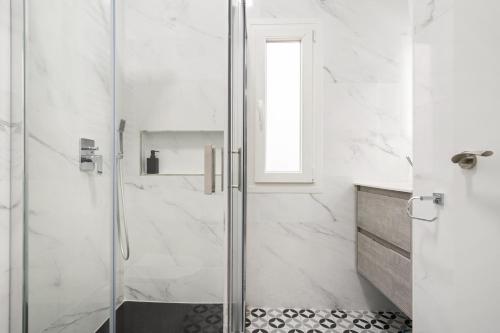 a shower with a glass door in a bathroom at Room Canalejas in Madrid