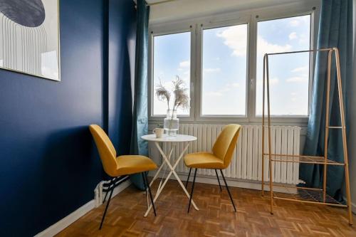 une table et deux chaises dans une pièce aux murs bleus dans l'établissement Studio Paris 14ème arrondissement - II, à Paris