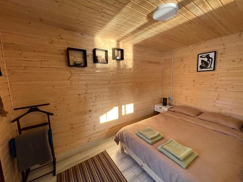 a bedroom with a bed and a wooden wall at Casa pe lac Bicaz in Bicaz