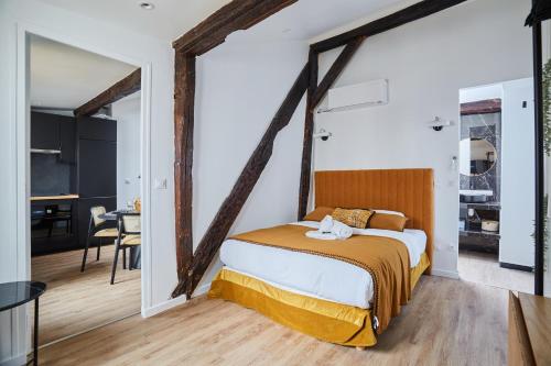 ein Schlafzimmer mit einem großen Bett und einem Tisch in der Unterkunft Apartment Le Marais by Studio prestige in Paris