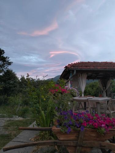 a patio with a table and flowers in the yard at b&b La Corte dei Cerri- Il Piccolo Chalet in Frassinoro