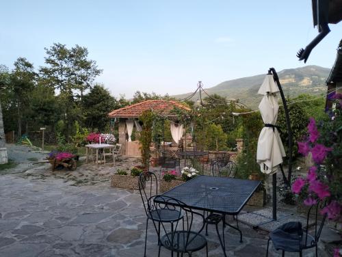 a patio with a table and chairs and an umbrella at b&b La Corte dei Cerri- Il Piccolo Chalet in Frassinoro