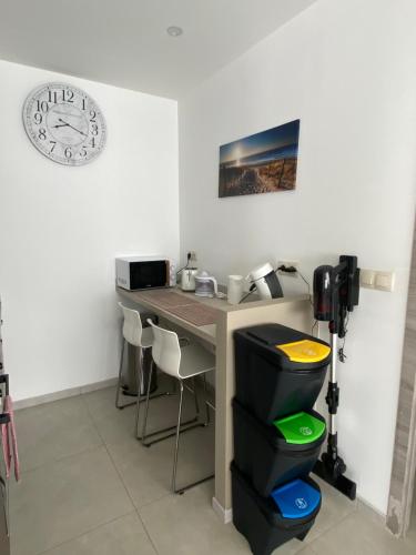 an office with a desk and a clock on the wall at 1-E Bel appart spacieux climatisé parking privé gratuit sur demande in Charleroi