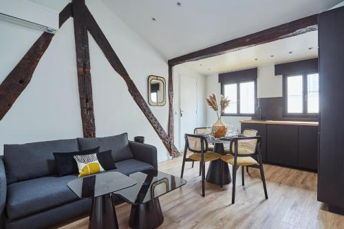 a living room with a couch and a table at Apartment Le Marais by Studio prestige in Paris