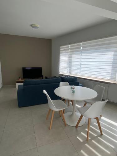 een woonkamer met een tafel en stoelen en een bank bij 1A01-Superbe appartement lumineux netflix gratuit in Charleroi