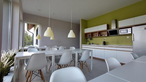 a kitchen with white tables and chairs and a kitchen with green at Rezydencja Ostoja in Stronie Śląskie