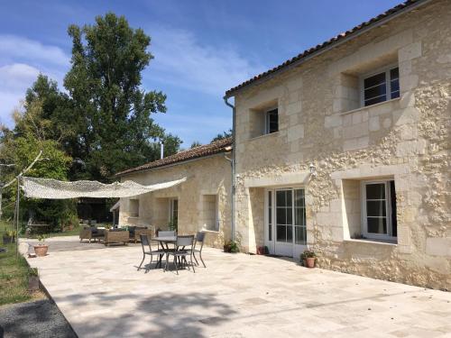 a patio with a table and chairs in front of a building at La Gelette in Génissac