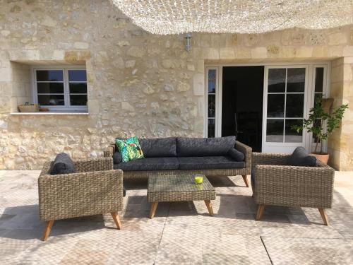 a couch and two chairs on a patio at La Gelette in Génissac
