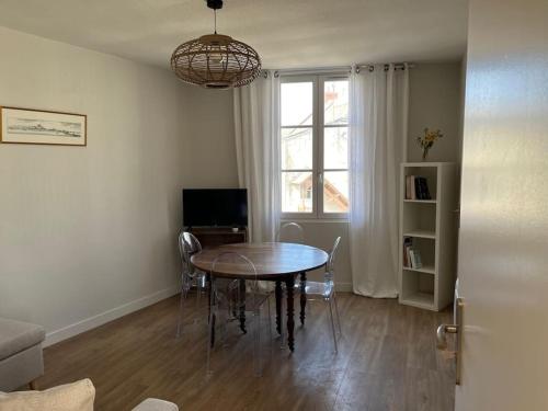 una sala da pranzo con tavolo e finestra di Appartement centre Saumur bord de Loire Les marronniers a Saumur