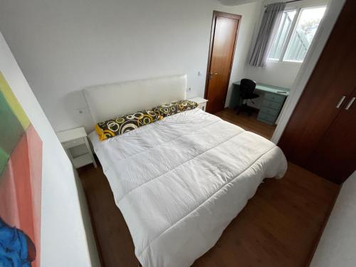1 dormitorio con 1 cama con sábanas y almohadas blancas en Casa Independiente Bella Vista, en Moaña