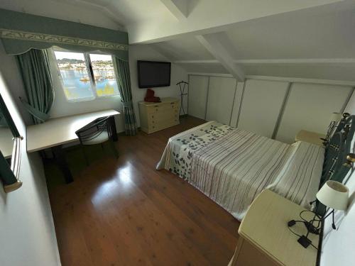 a small bedroom with a bed and a television at Casa Independiente Bella Vista in Moaña
