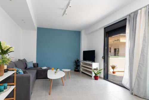 a living room with a couch and a tv at PROPAN CITY SUITES in Volos
