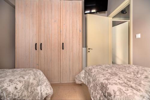 a bedroom with two beds and a closet at Chalet Perivoli in Perivólion