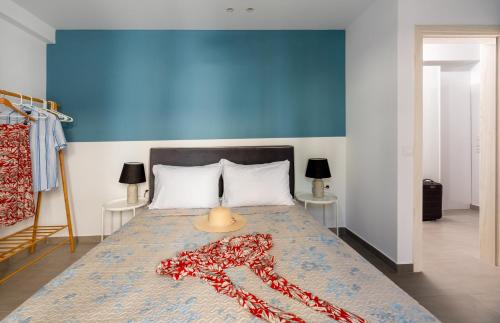 a bedroom with a large bed with a blue wall at PROPAN CITY SUITES in Volos