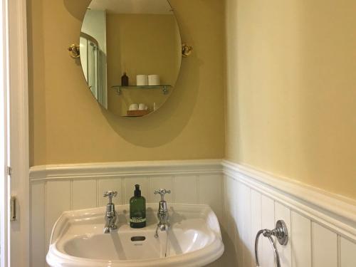 a bathroom with a sink and a mirror at Rutherford House in Town Yetholm