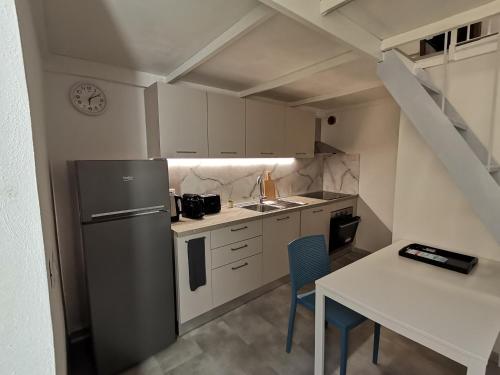 a kitchen with a refrigerator and a table with chairs at Da amènte in Alassio