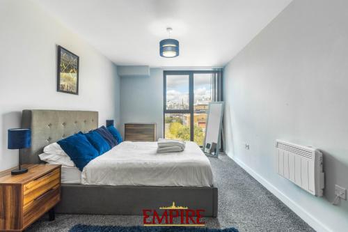 Un dormitorio con una cama grande y una ventana. en 1 Bedroom Apartments in Digbeth, en Birmingham