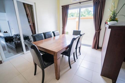 a dining room with a wooden table and chairs at Pattaya 6 bedroom pool villa in Jomtien Beach