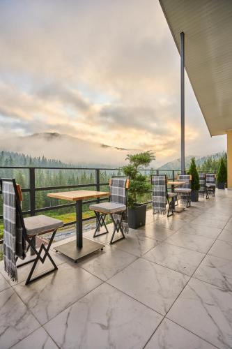 a patio with tables and chairs and a view at Готель У Борисовича & SPA in Palyanytsya