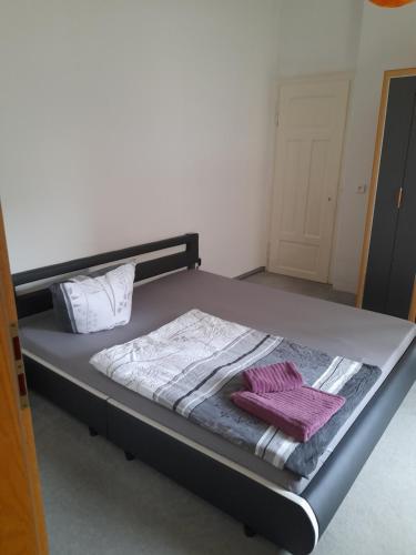 uma cama num quarto com toalhas roxas em Schöne Wohnung für Monteure und sonstige Reisende em Zwickau