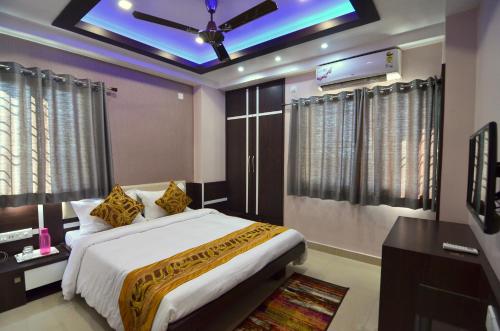 a bedroom with a large bed with a ceiling fan at Tulip Residency in Dibrugarh