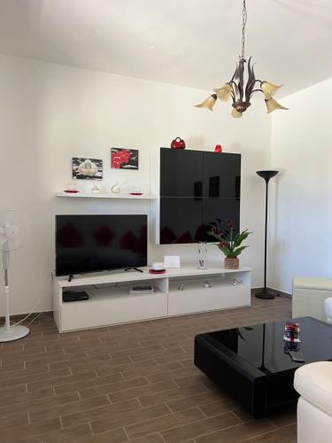 una sala de estar con un centro de entretenimiento blanco con TV de pantalla plana en Villa Rosaria, en Tollo