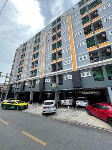 a large building with cars parked in a parking lot at ruamsab apartment1 in Bangkok
