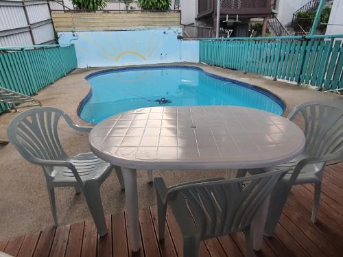 a table and chairs in front of a swimming pool at Spacious 3 BRM Apartment in Suva