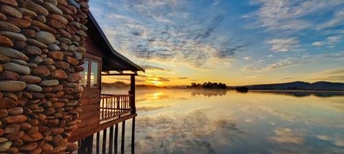a house with a balcony and a body of water at De Zeekoe Guest Farm in Oudtshoorn