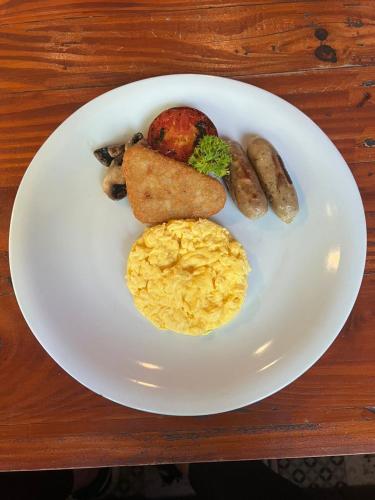 a white plate with breakfast foods on a table at Griya Shanti Suites in Sanur