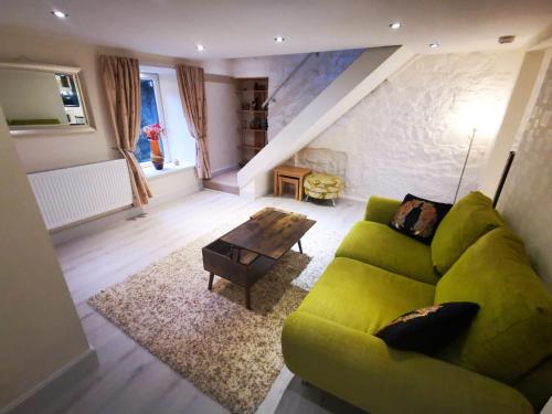 a living room with a green couch and a table at 2-level apartment in Aberdeen