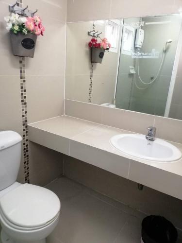 a bathroom with a sink and a toilet and a mirror at ruamsab apartment1 in Bangkok