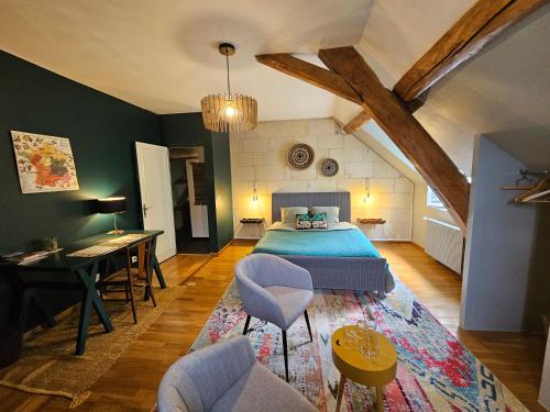 een slaapkamer met een bed en een tafel en stoelen bij malitourne in Brissac-Quincé