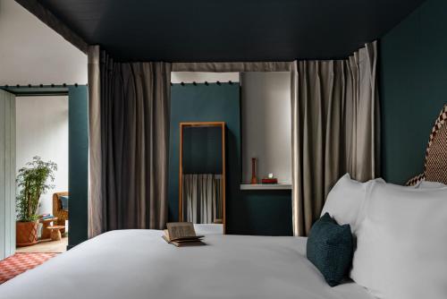 a bedroom with a bed with a book on it at Cowley Manor Experimental in Cheltenham