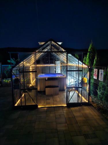 a greenhouse with a table in it at night at Apartamenty pod Gromadzyniem in Ustrzyki Dolne