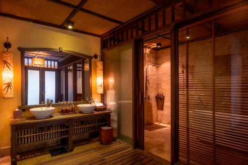 a bathroom with two sinks and a walk in shower at Melia Ba Vi Mountain Retreat in Hanoi
