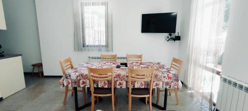 comedor con mesa con sillas y TV en Mountain Pearls Home 9, en Vodata
