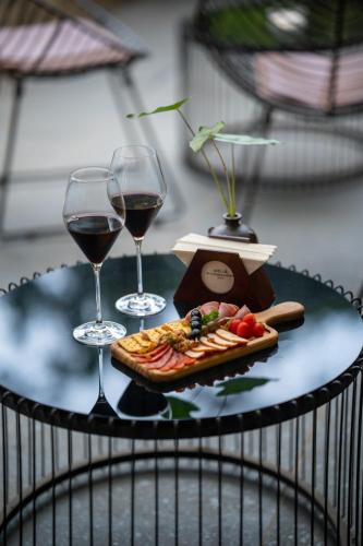 two glasses of wine and a plate of food on a table at Melia Ba Vi Mountain Retreat in Hanoi
