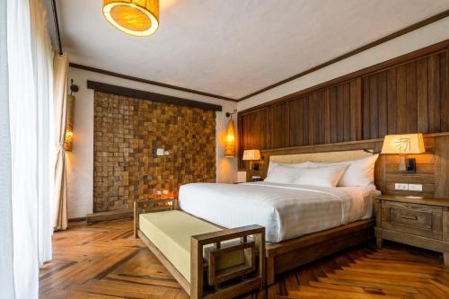 a bedroom with a large bed and a brick wall at Melia Ba Vi Mountain Retreat in Hanoi