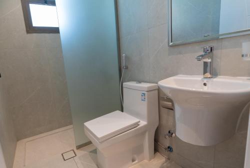 a bathroom with a white toilet and a sink at Emaar Holiday Homes Business Gate Al Murouj - A in Riyadh