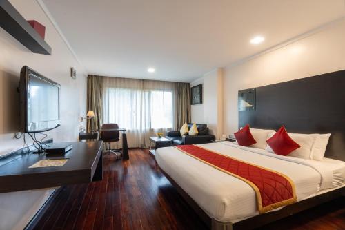 um quarto de hotel com uma cama grande e uma secretária em 37th Crescent Hotel Bengaluru em Bangalore