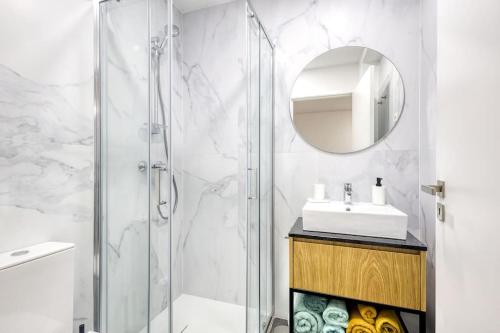 Un baño con ducha, lavabo y espejo. en Cosy flat, Braga city center, en Braga