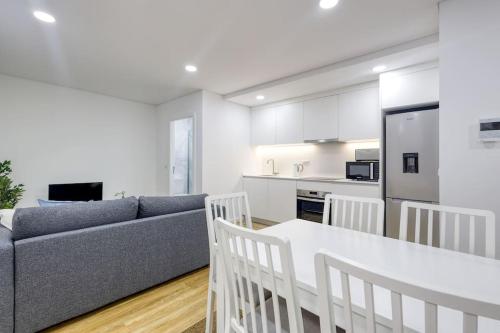 a kitchen and living room with a couch and a table at Cosy flat, Braga city center in Braga