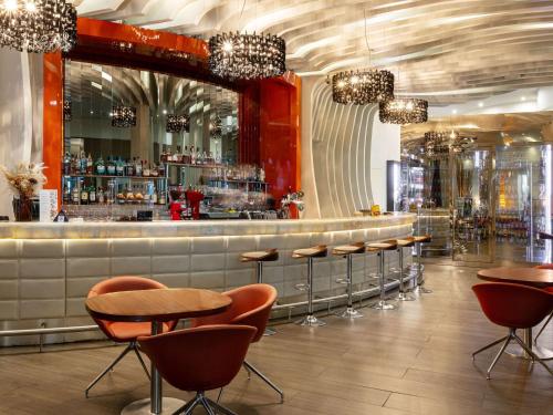 a restaurant with a bar with chairs and a counter at Novotel Moscow City in Moscow