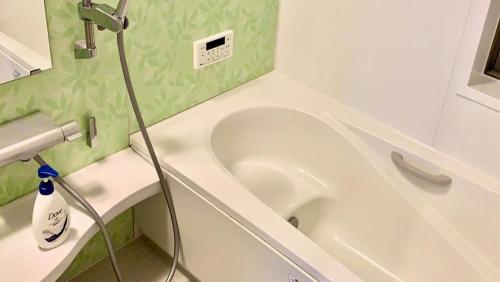 富士河口湖的住宿－貸別荘 ウサギの郷，浴室设有位于水槽旁的白色浴缸。